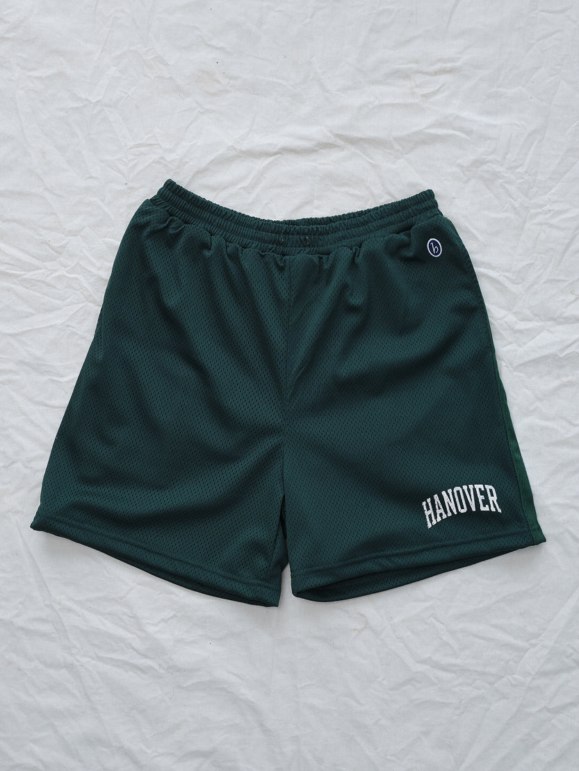 Green shorts with 'Hanover' text on a textured white background