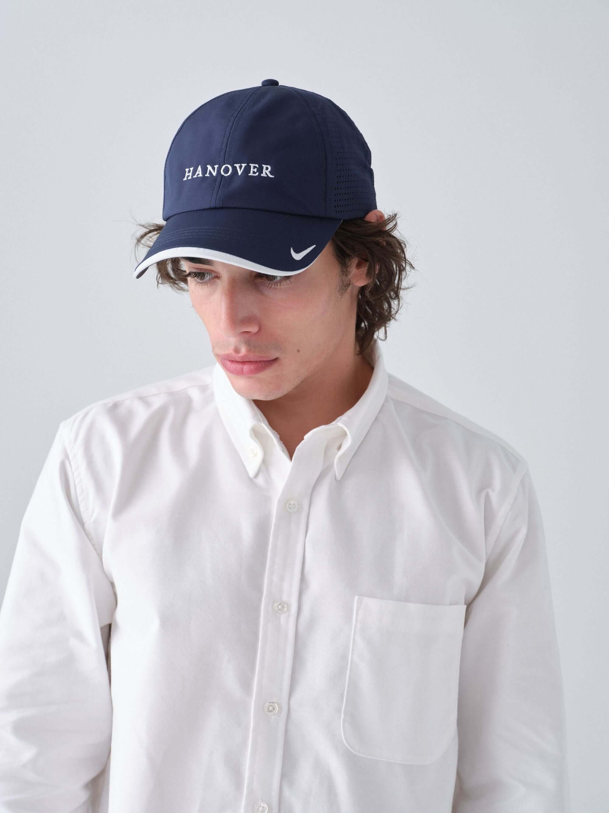 Hanover Performance hat in navy on model with 'Hanover' embroidery