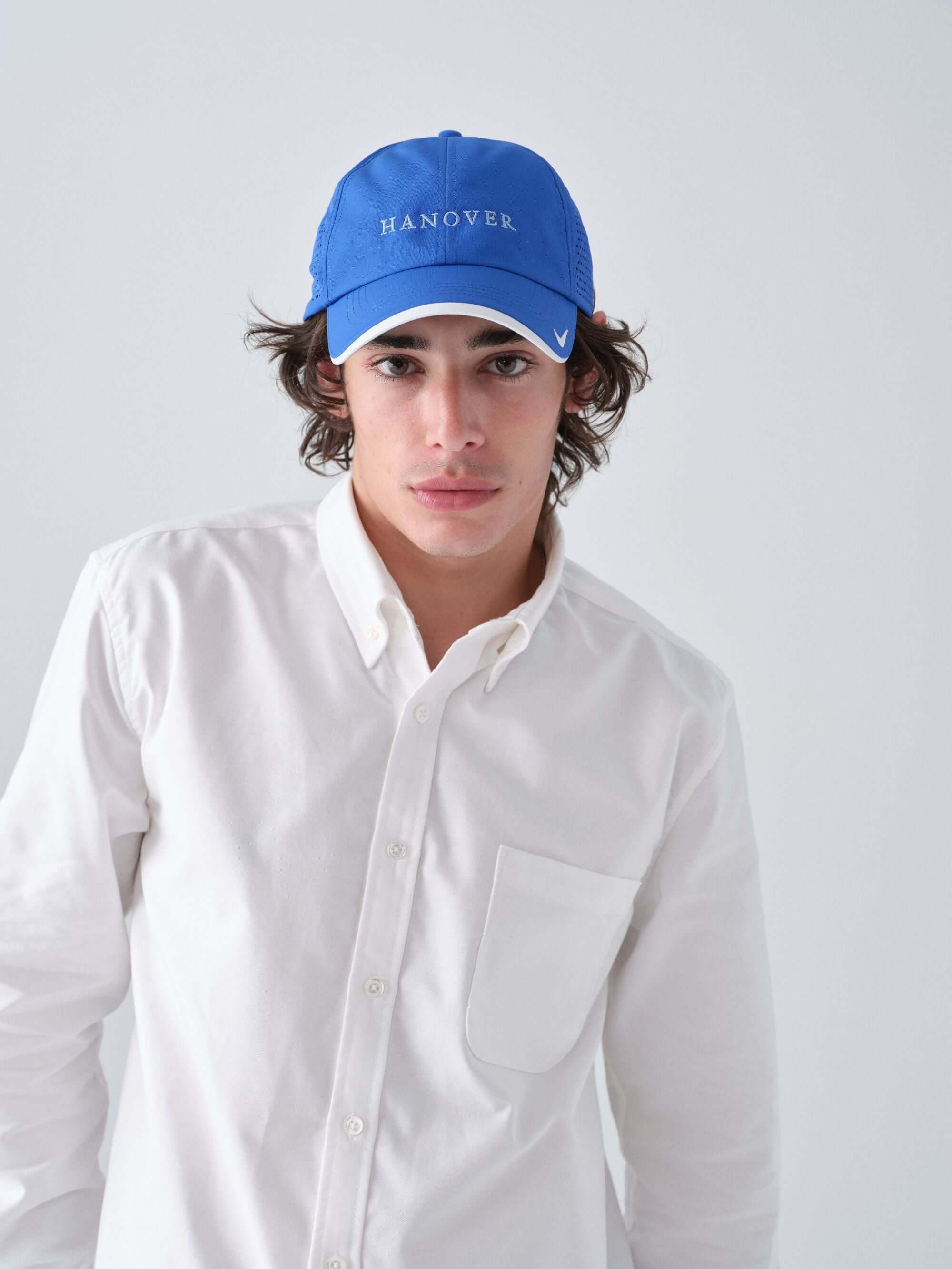 Hanover Performance hat in royal on model with 'Hanover' embroidery