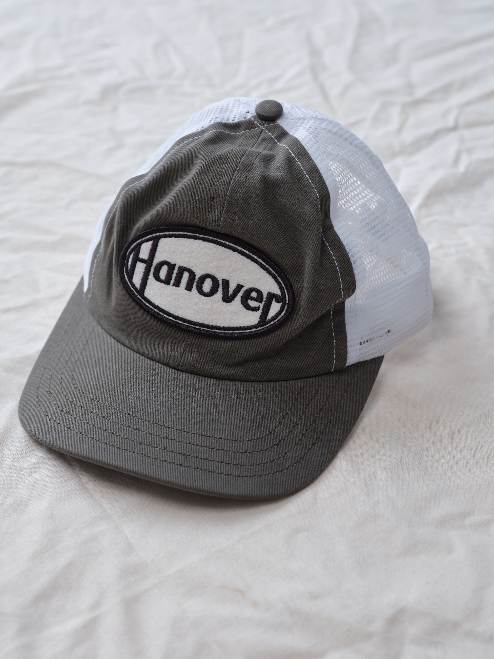 Hanover Trucker Hat flat lay textured background side view