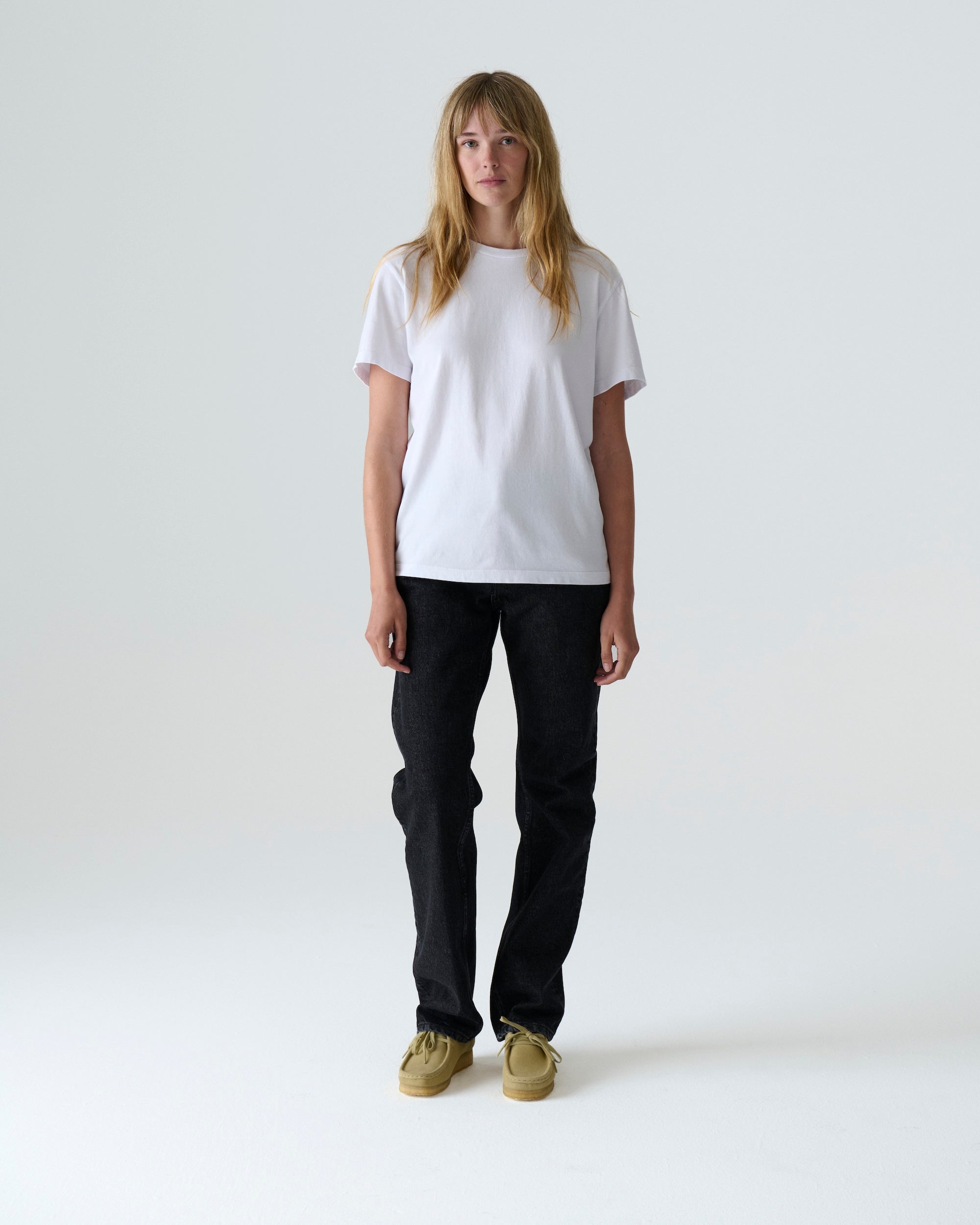 Woman wearing Drift Jeans in Washed Black, classic straight-fit, made from midweight denim, handcrafted garment-wash process.