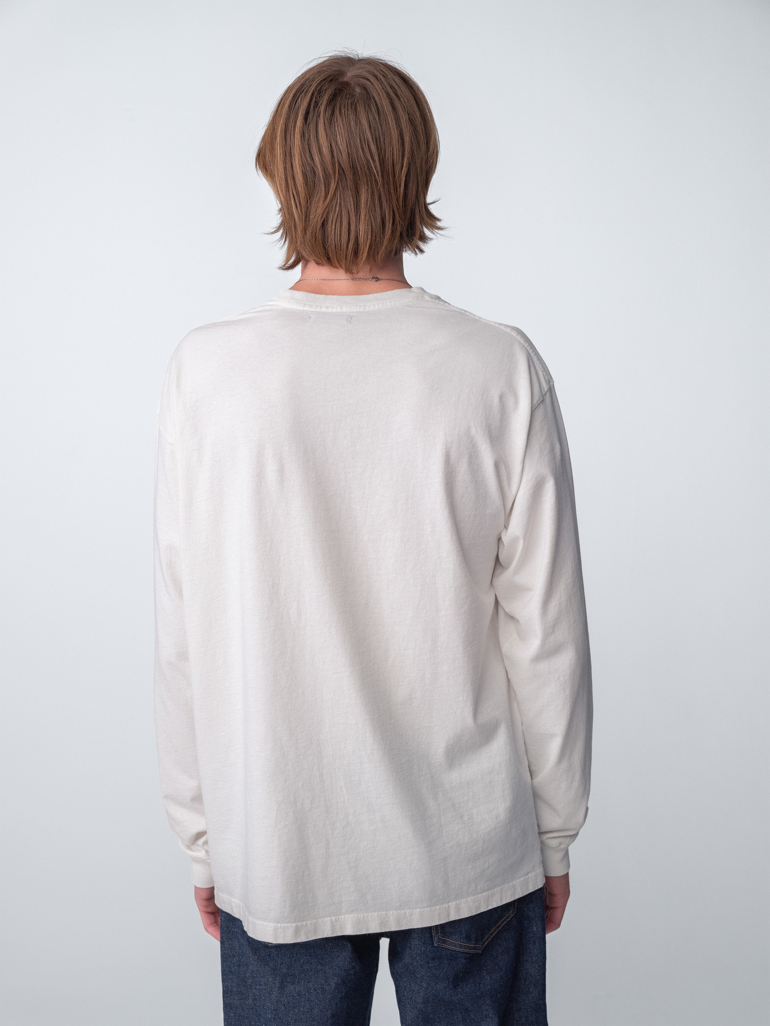 Back view of a casual model wearing a Hanover Long Sleeve Tee in washed white cotton.