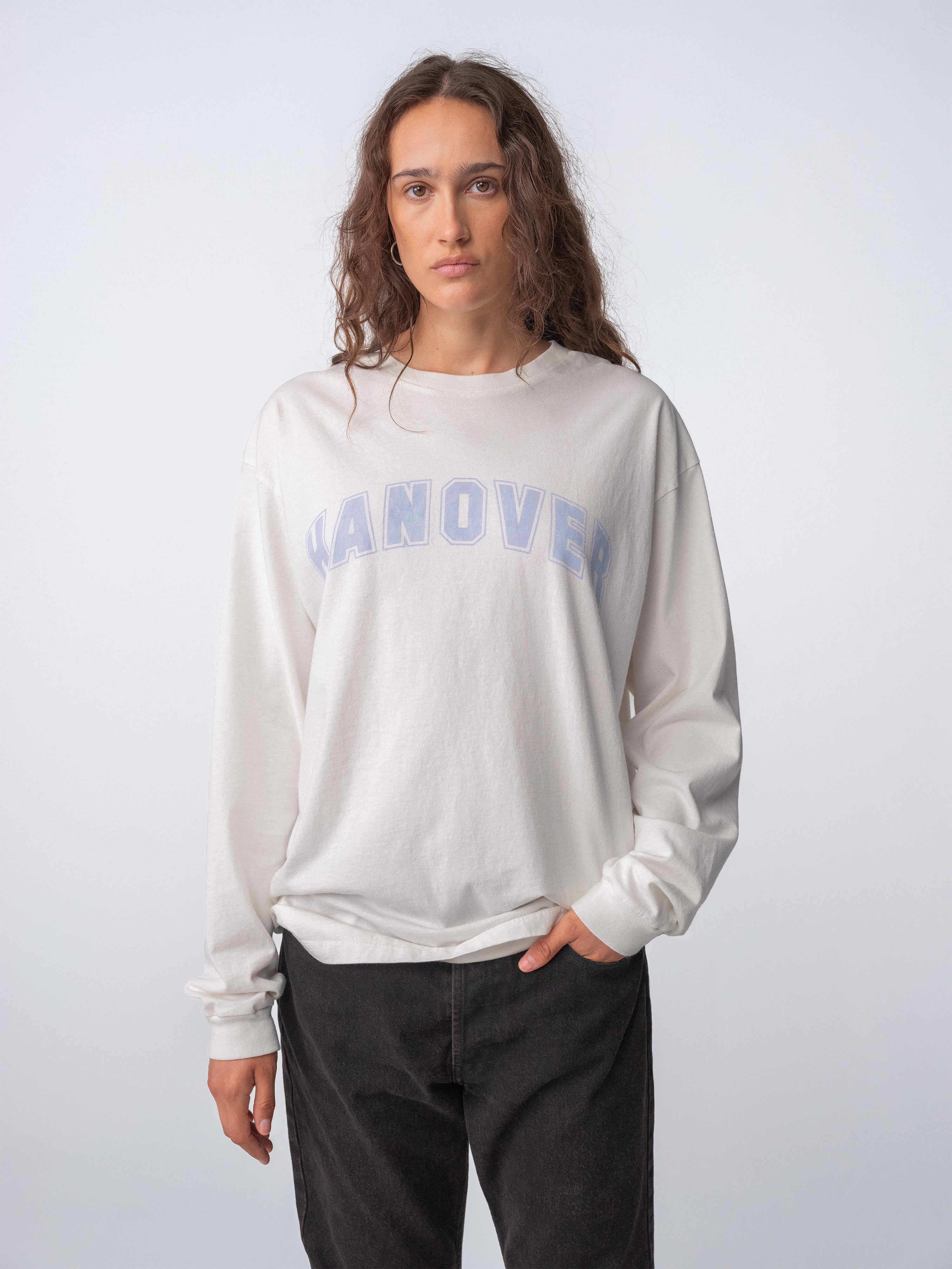 Woman wearing a Hanover Long Sleeve Tee in natural washed white with faded light purple graphic.