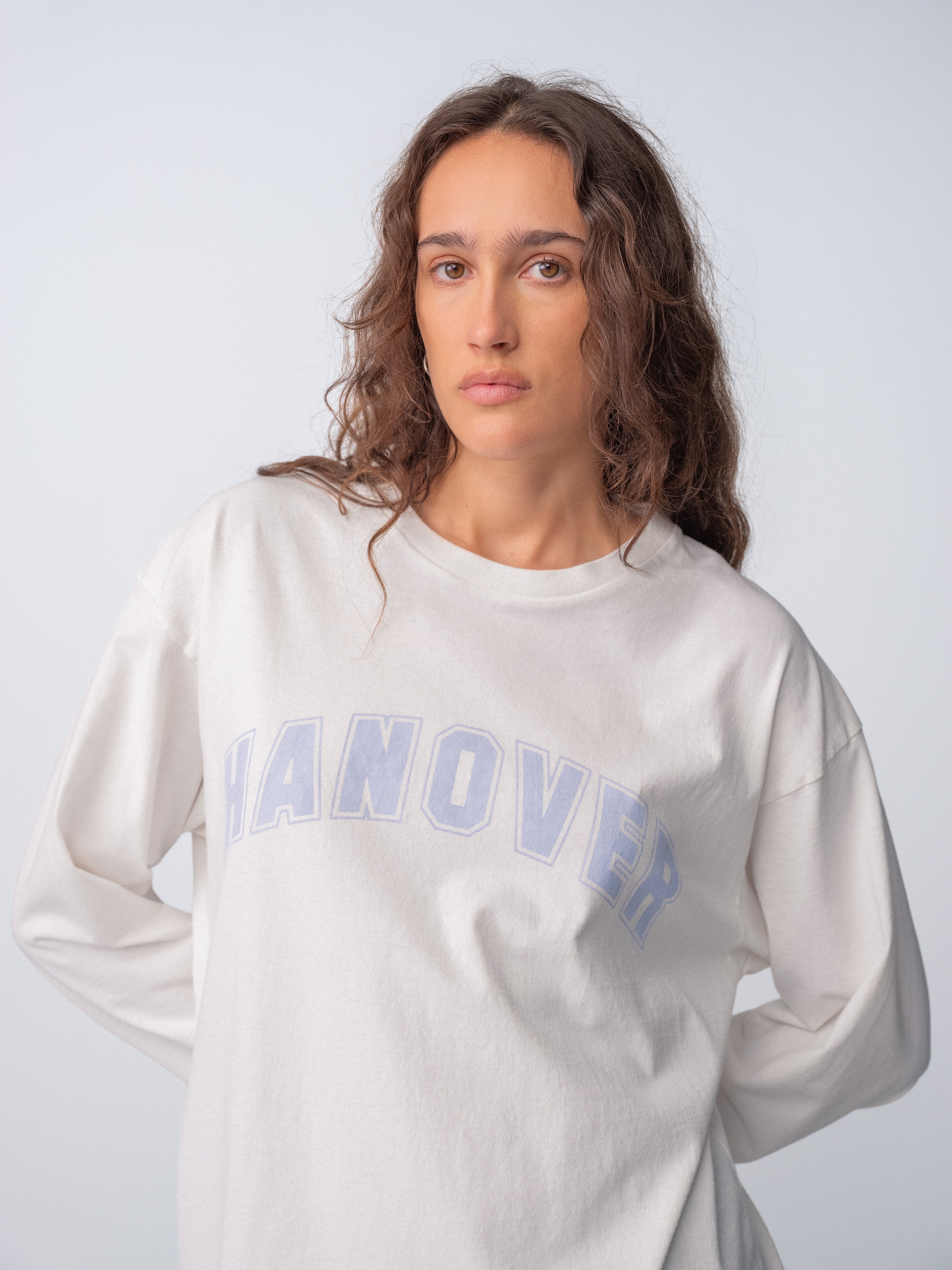Model wearing a faded light purple Hanover Long Sleeve Tee in natural washed white cotton.