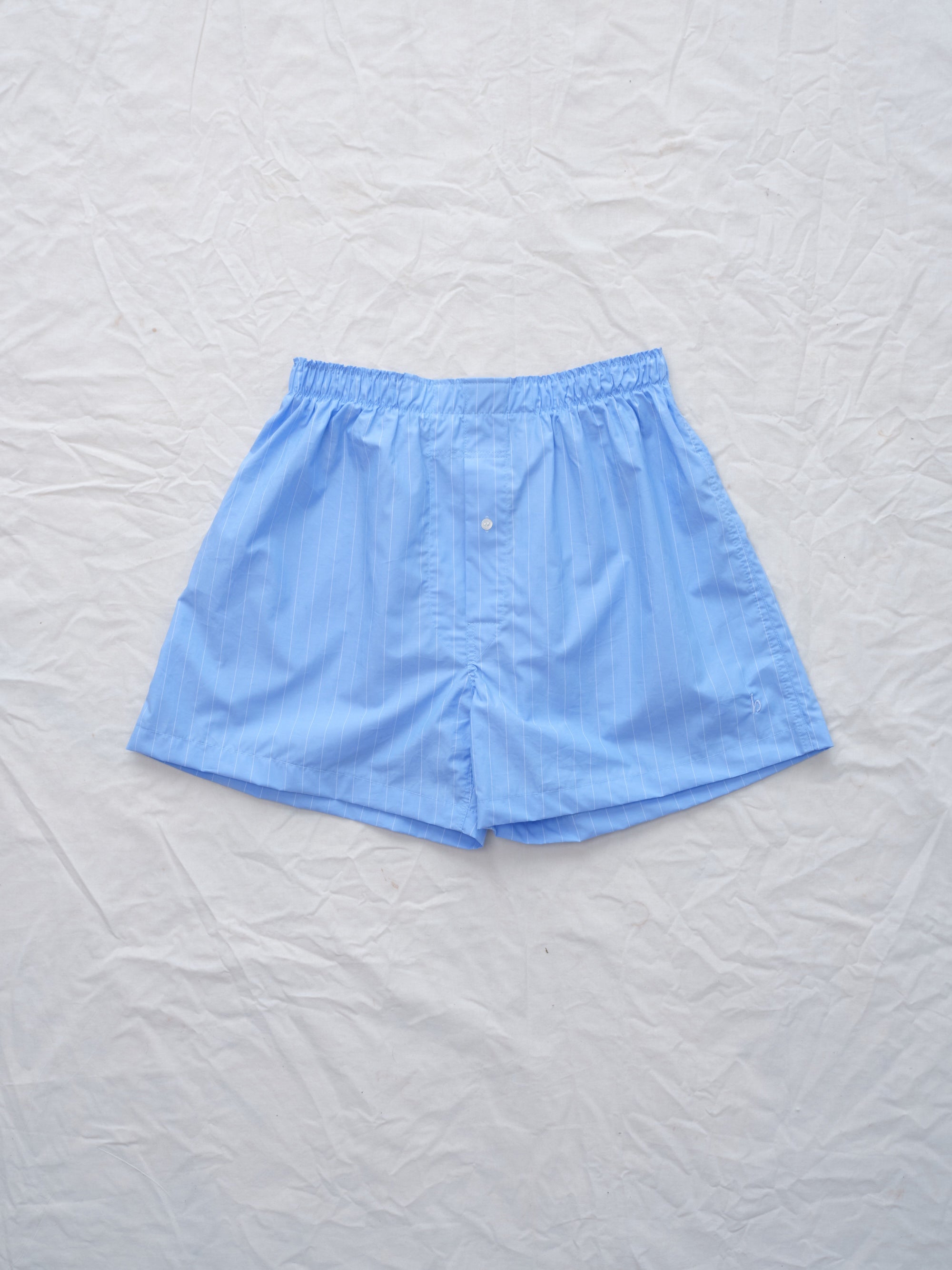 Light blue boxer shorts on a textured white background