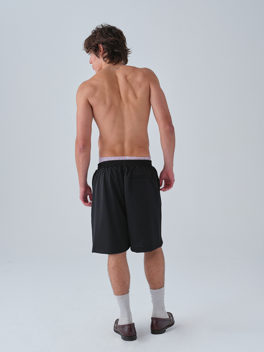 Man wearing black shorts on a plain background hanover