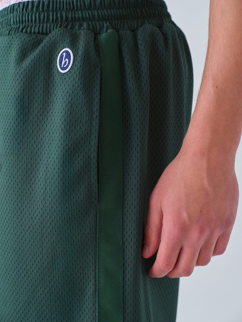 Green athletic shorts with a brand logo on a white background