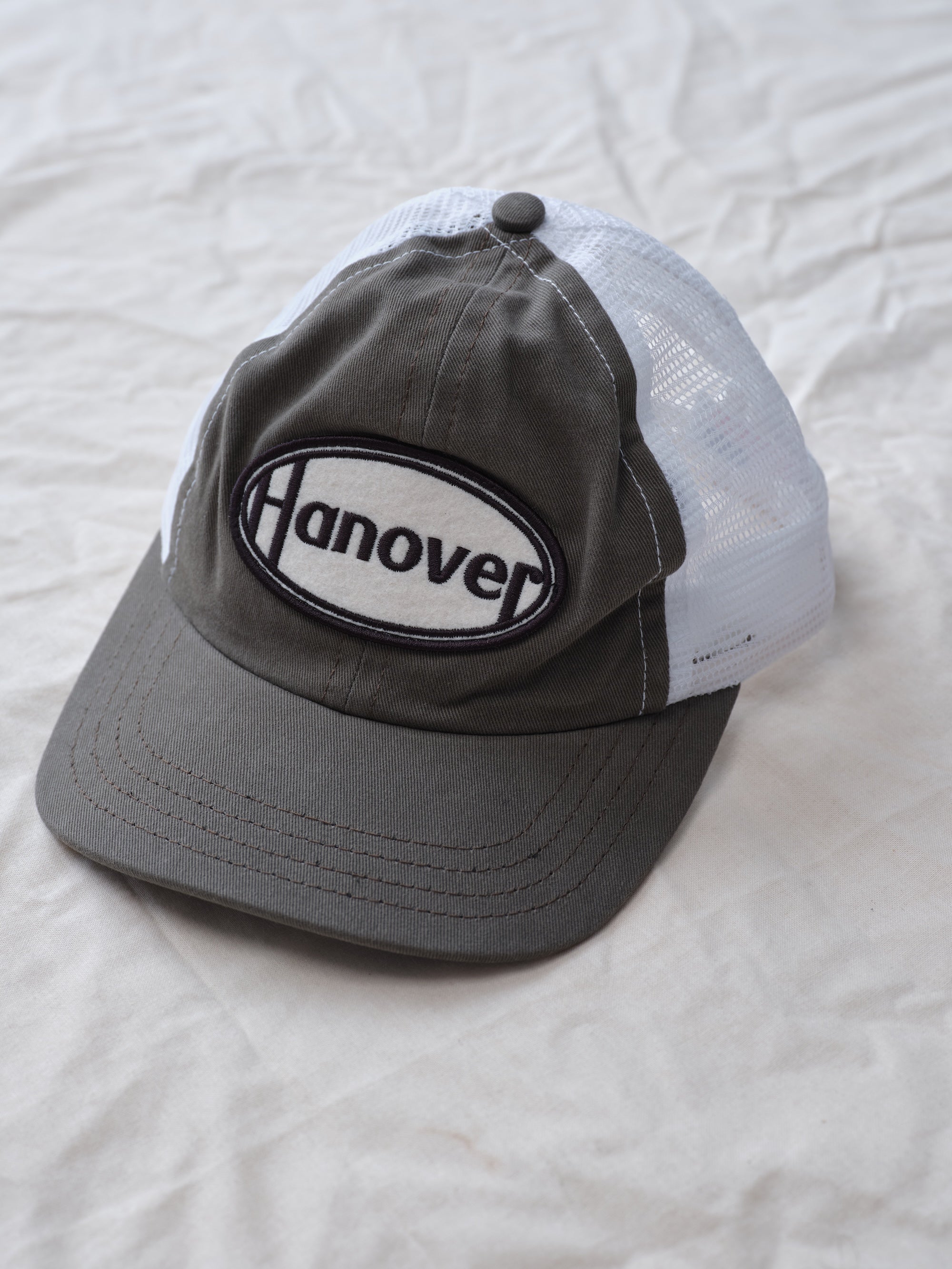 Hanover Trucker Hat flat lay textured background side view