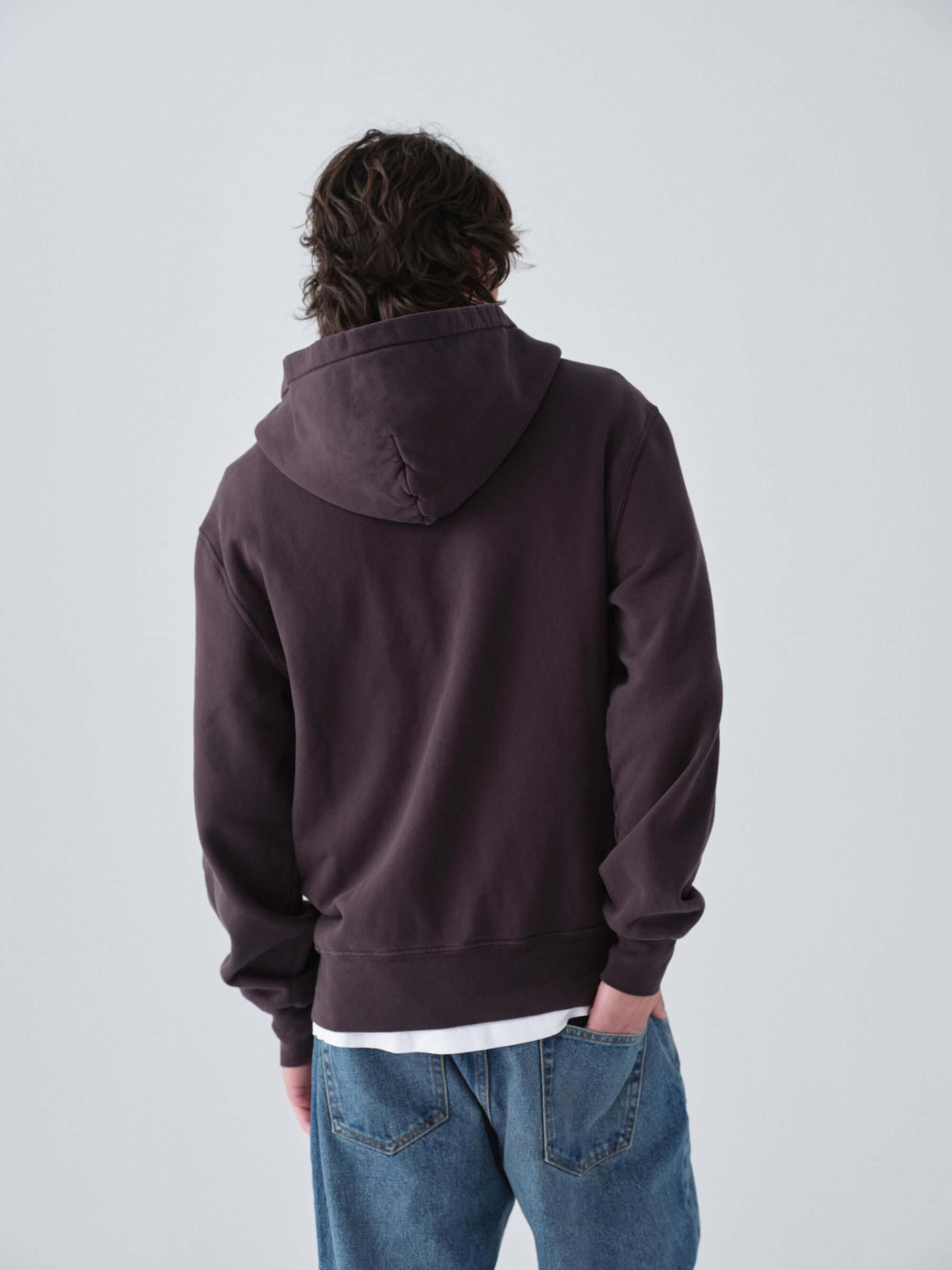 Person wearing a dark zip hoodie and Wander jeans against a plain background