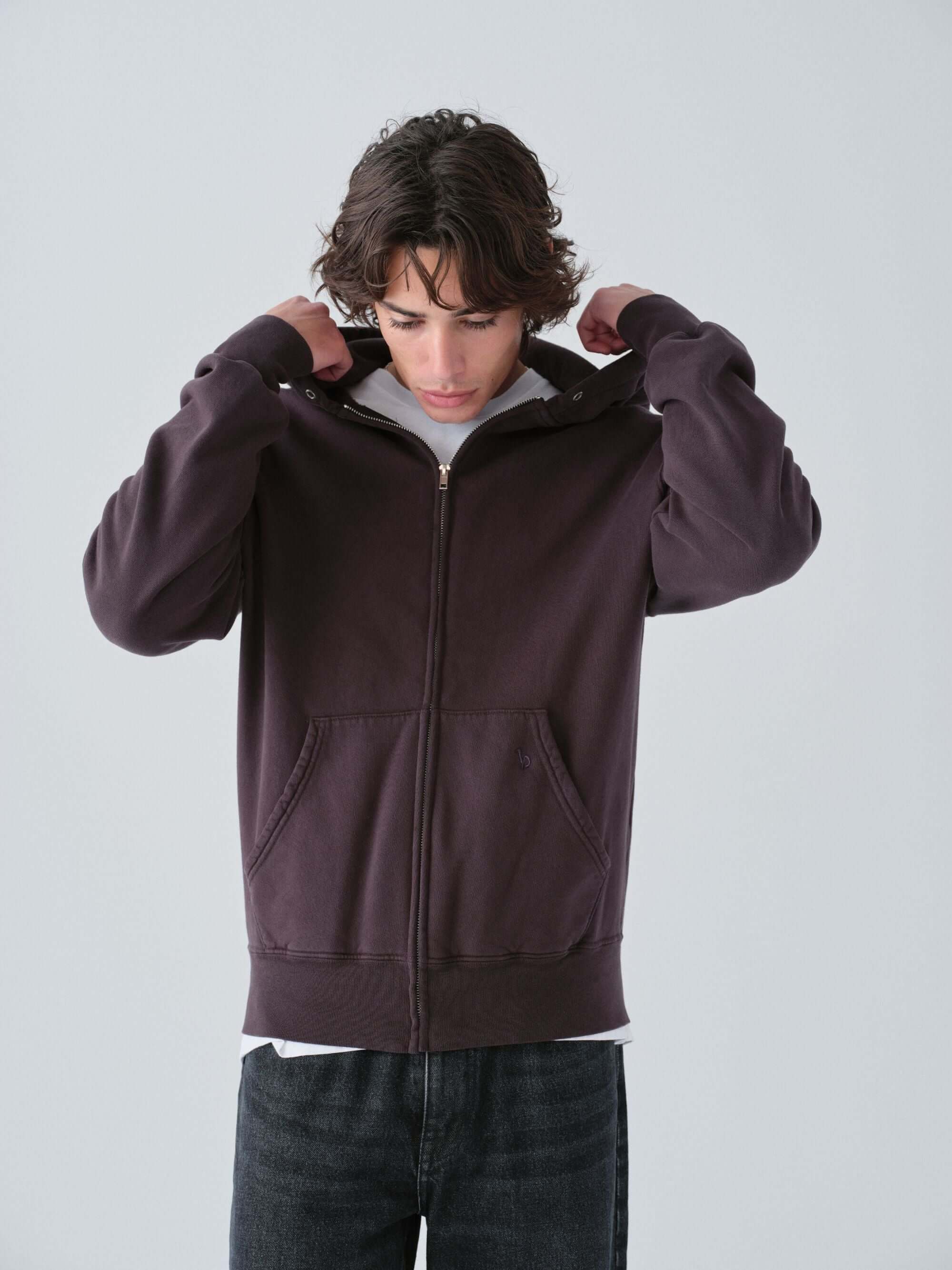 Person wearing a Hanover dark brown zip-up hoodie on a light gray background