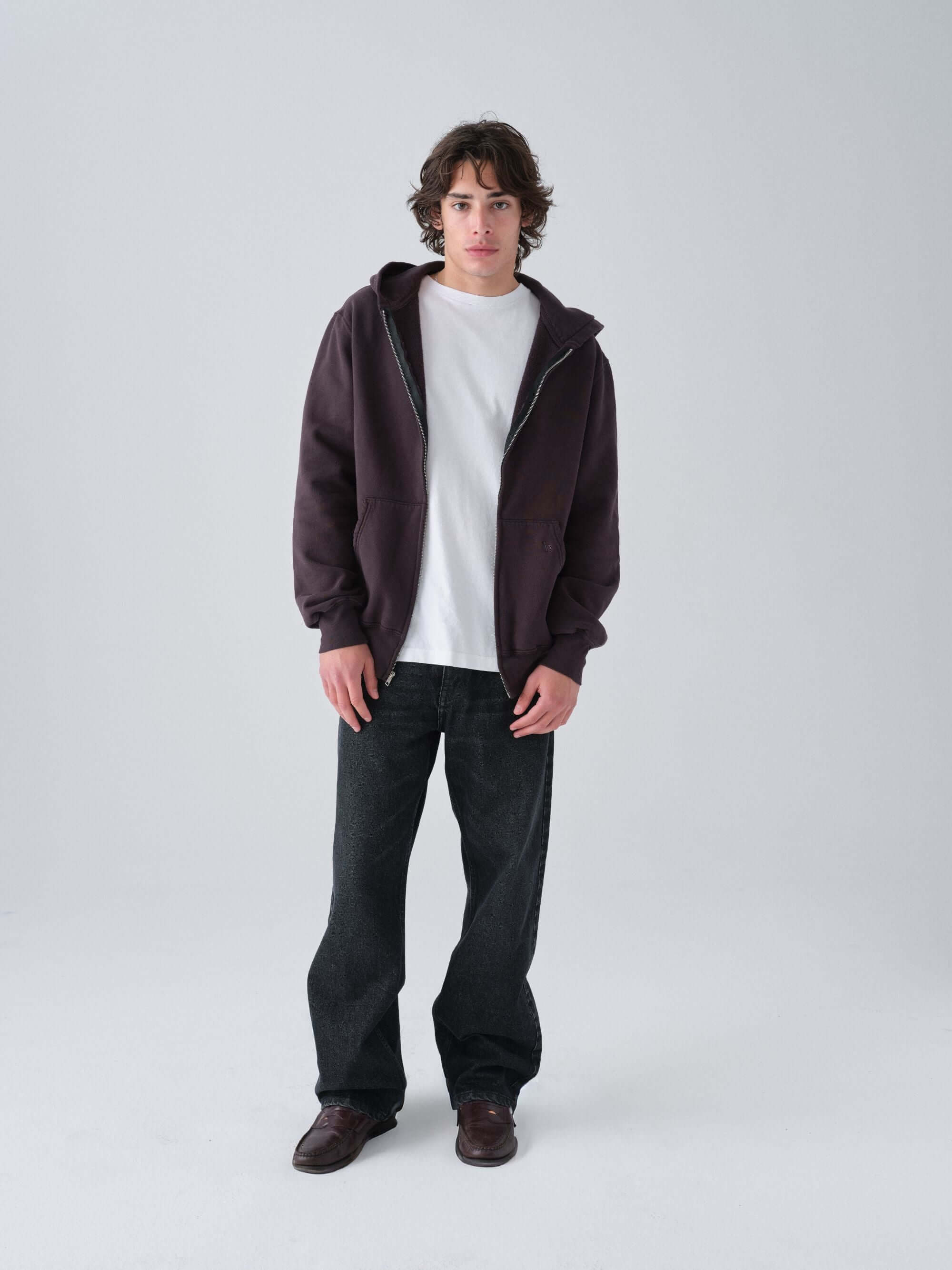 Person wearing a Hanover brown zip hoodie, white shirt, and Wander jeans on a white background