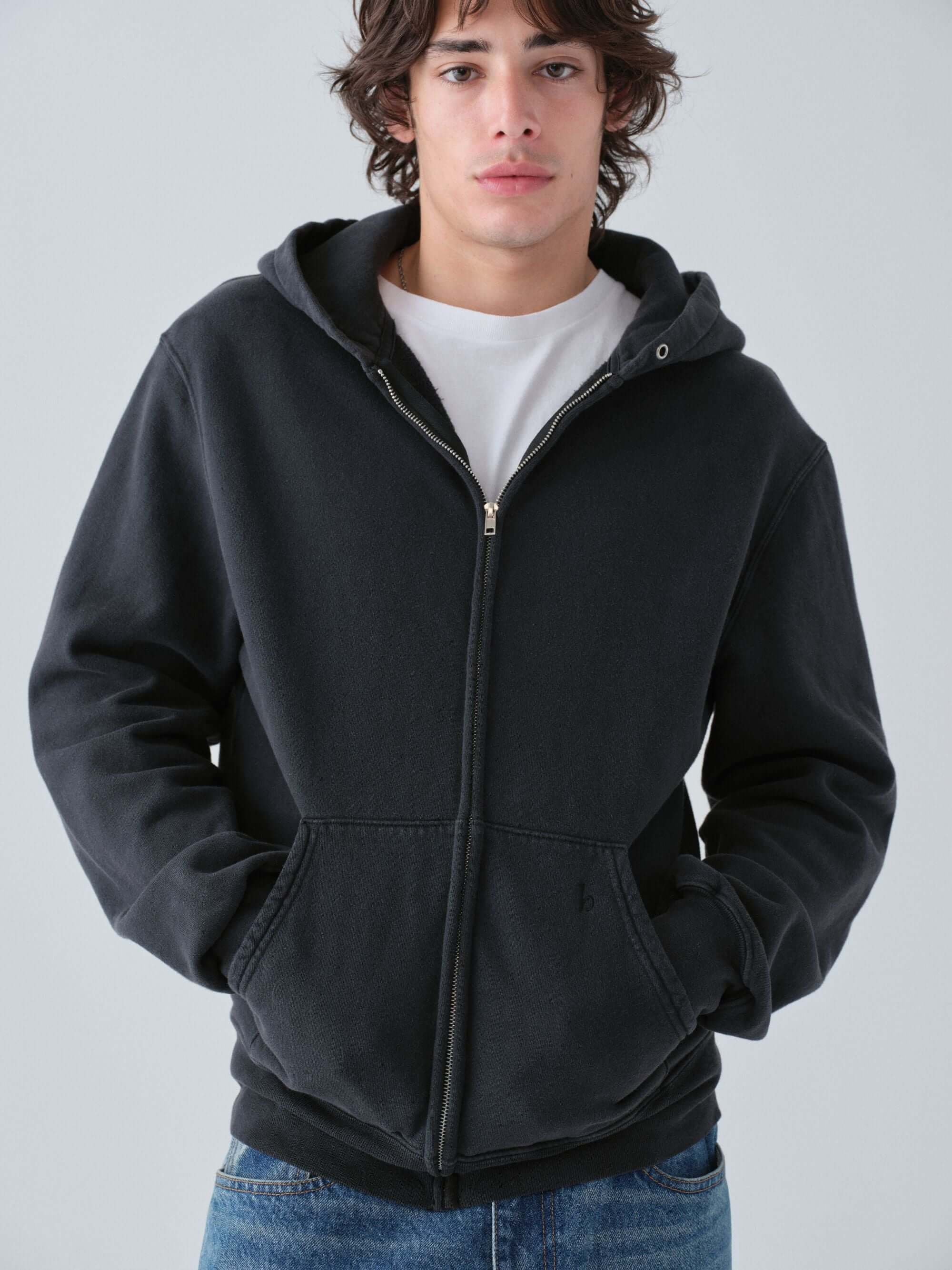 Person wearing a Hanover vintage black zip hoodie with a plain background