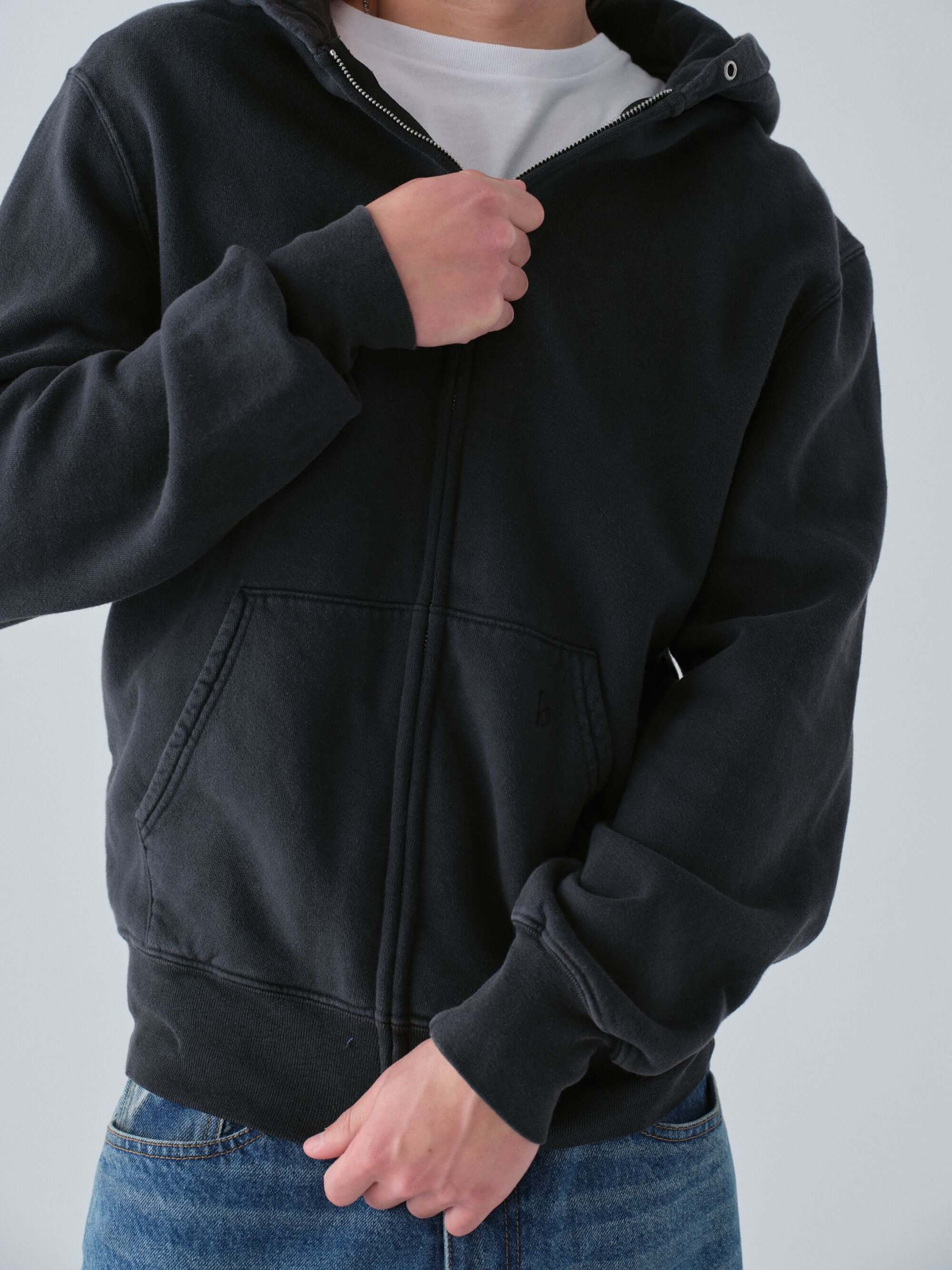 Hanover Person wearing a vintage black zip black hoodie with a plain background