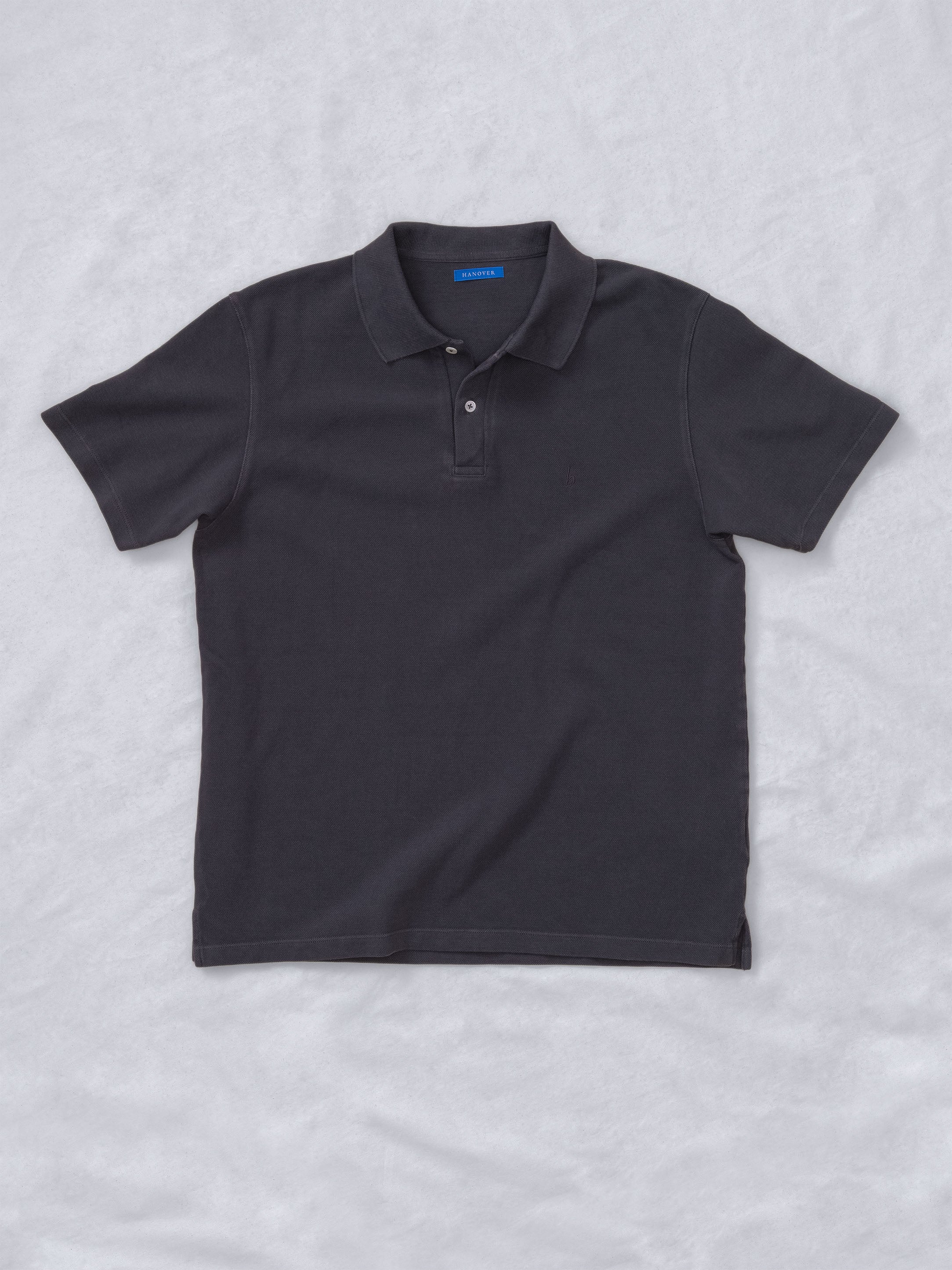 Sunwashed Staple Polo Shirt in dark color, showcasing soft and structured pique cotton fabric.