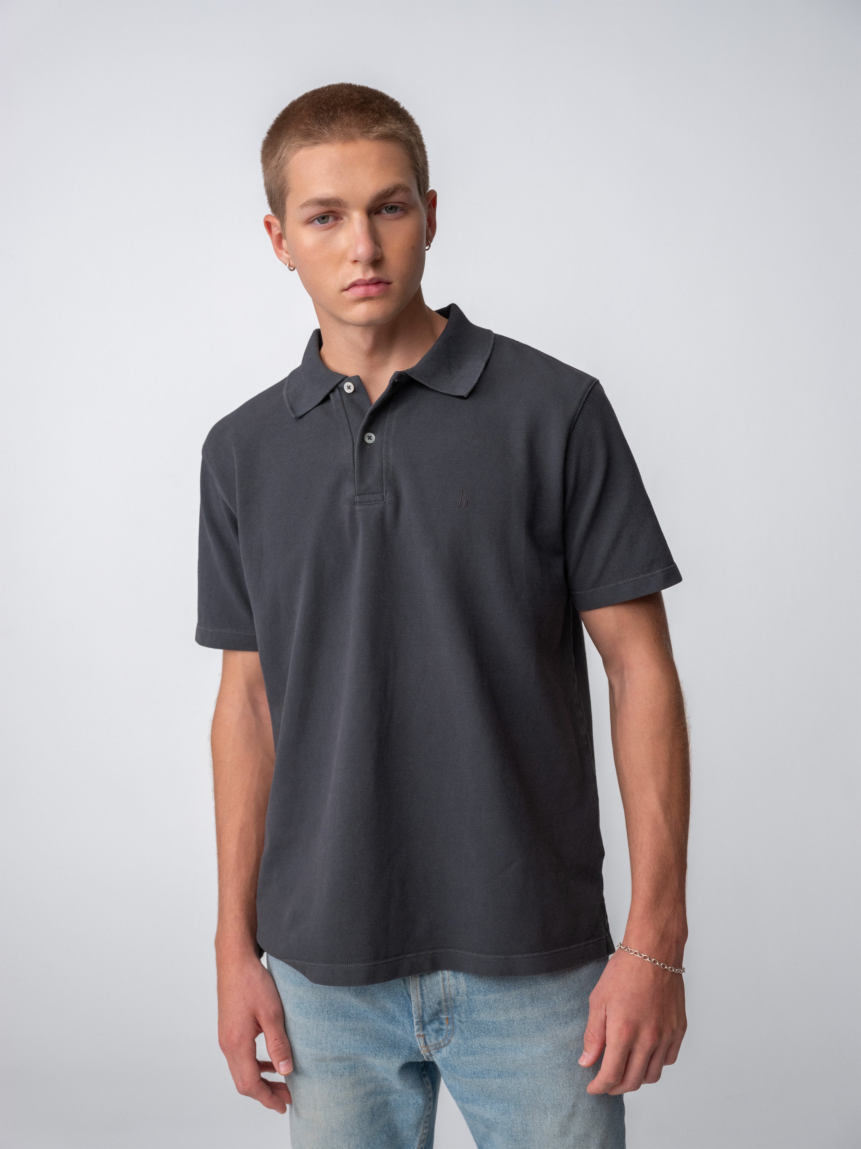 Model wearing a Sunwashed Staple Polo Shirt, showcasing its casual fit and comfortable style in a studio setting.