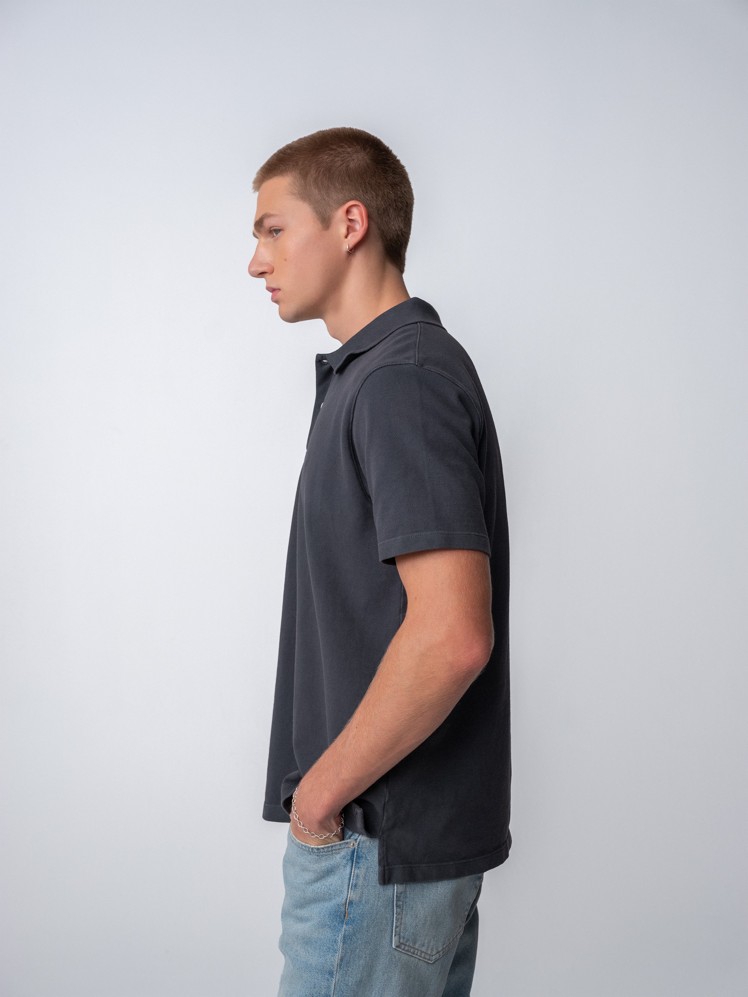 Model wearing the Sunwashed Staple Polo Shirt in a side profile view, showcasing its casual style and fit.