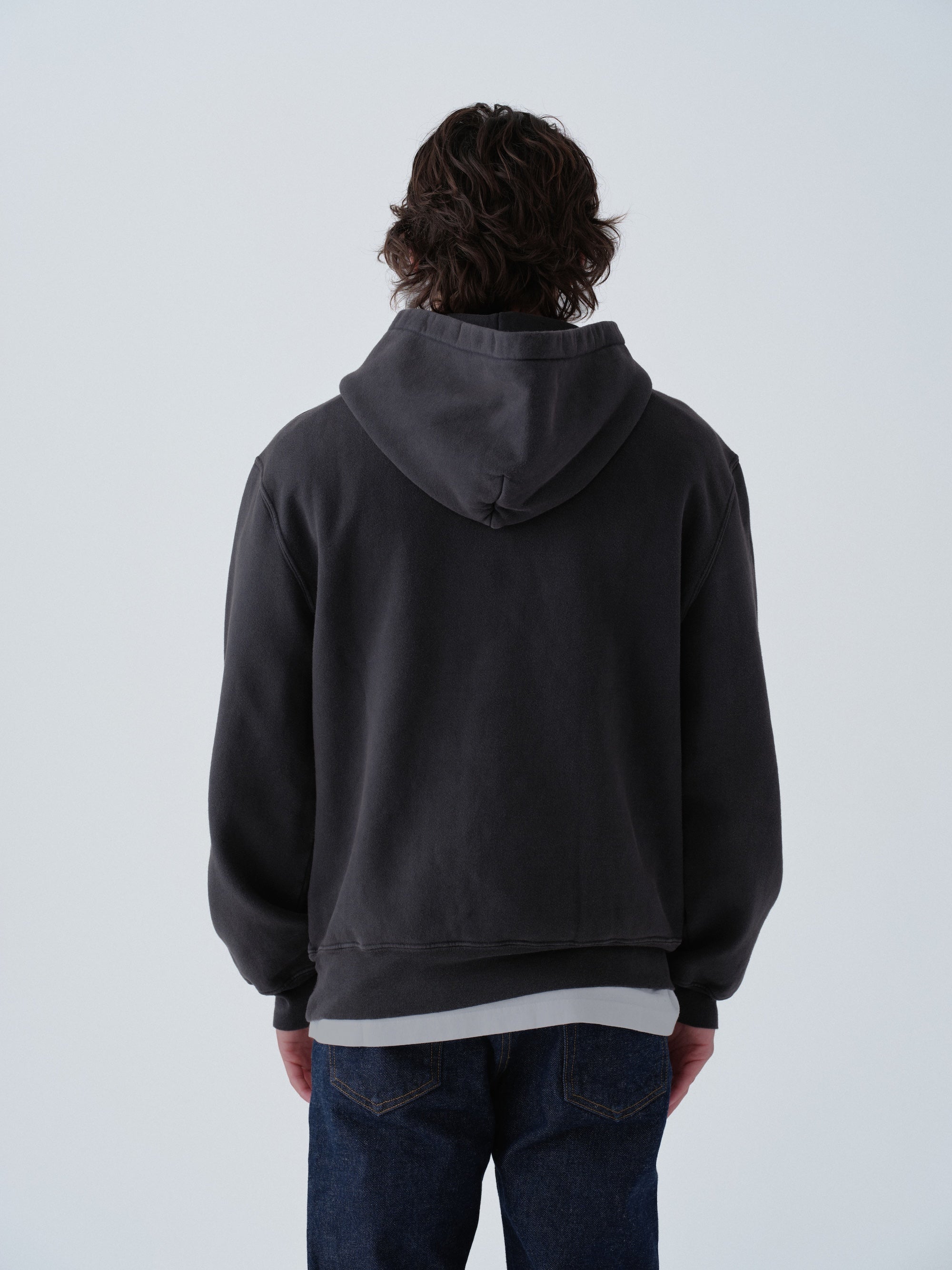 Model wearing Sunwashed Staple Hoodie in vintage black back view