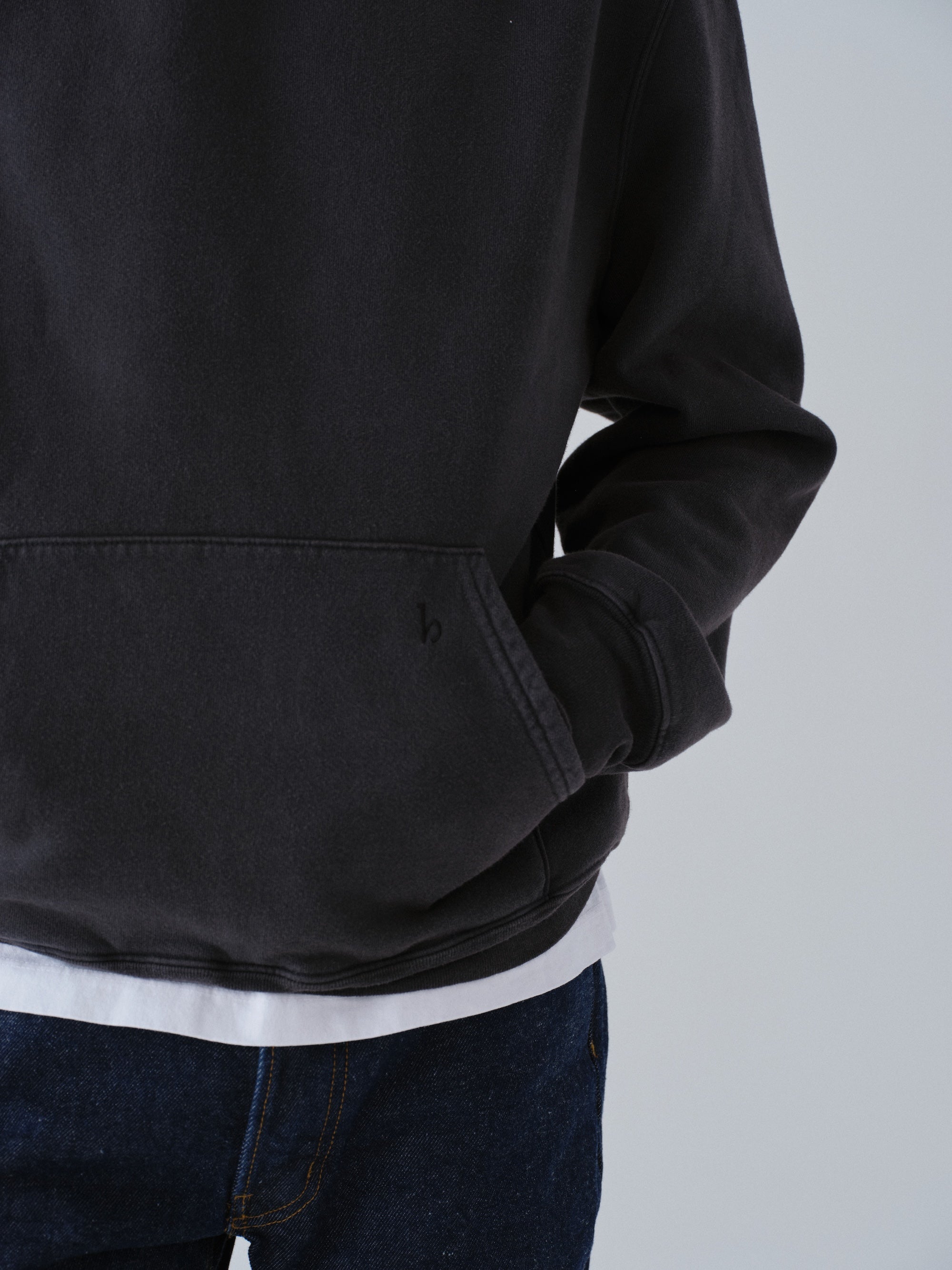 Model wearing Sunwashed Staple Hoodie in vintage black close up detail