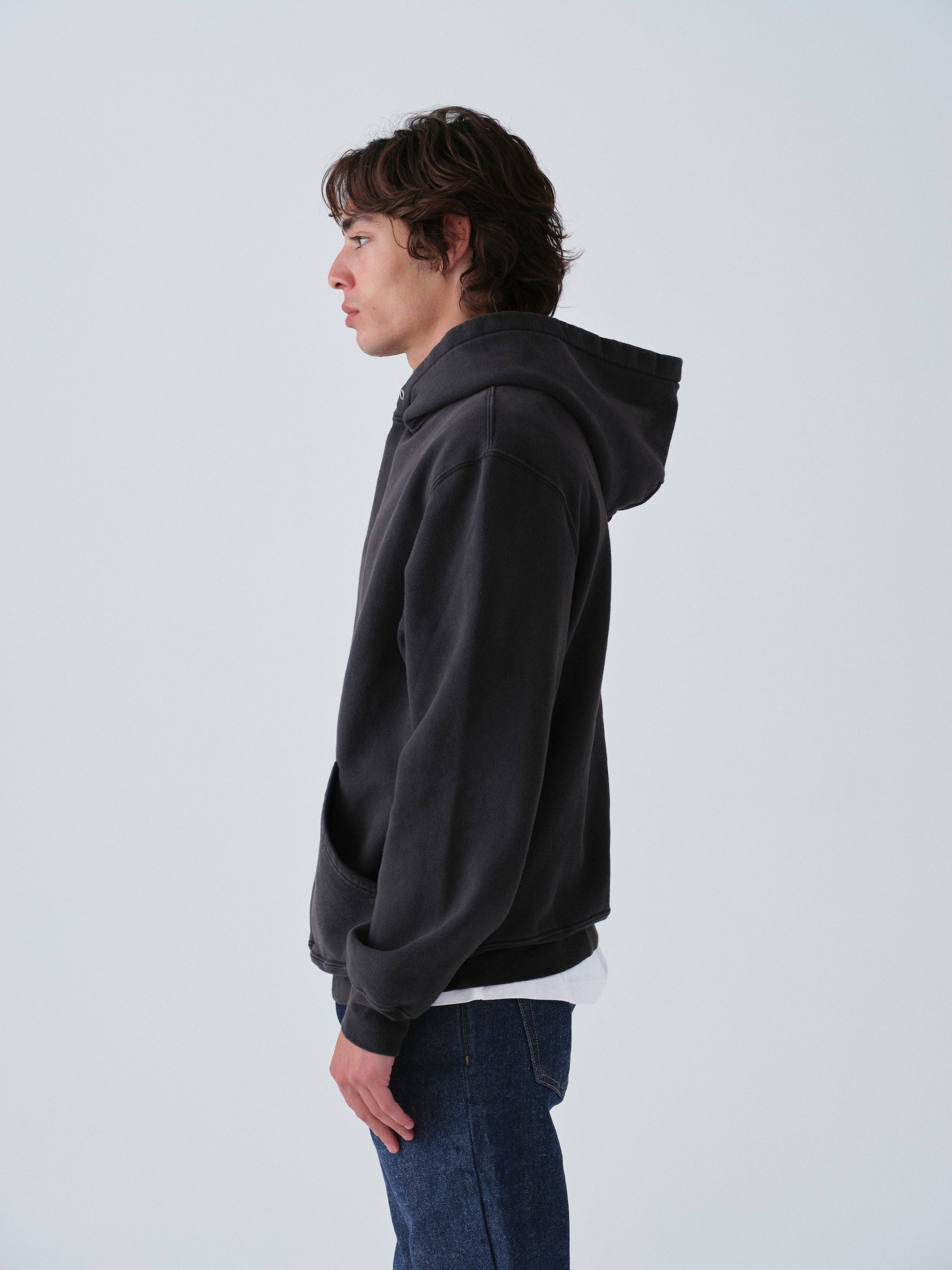 Model wearing Sunwashed Staple Hoodie in vintage black side view