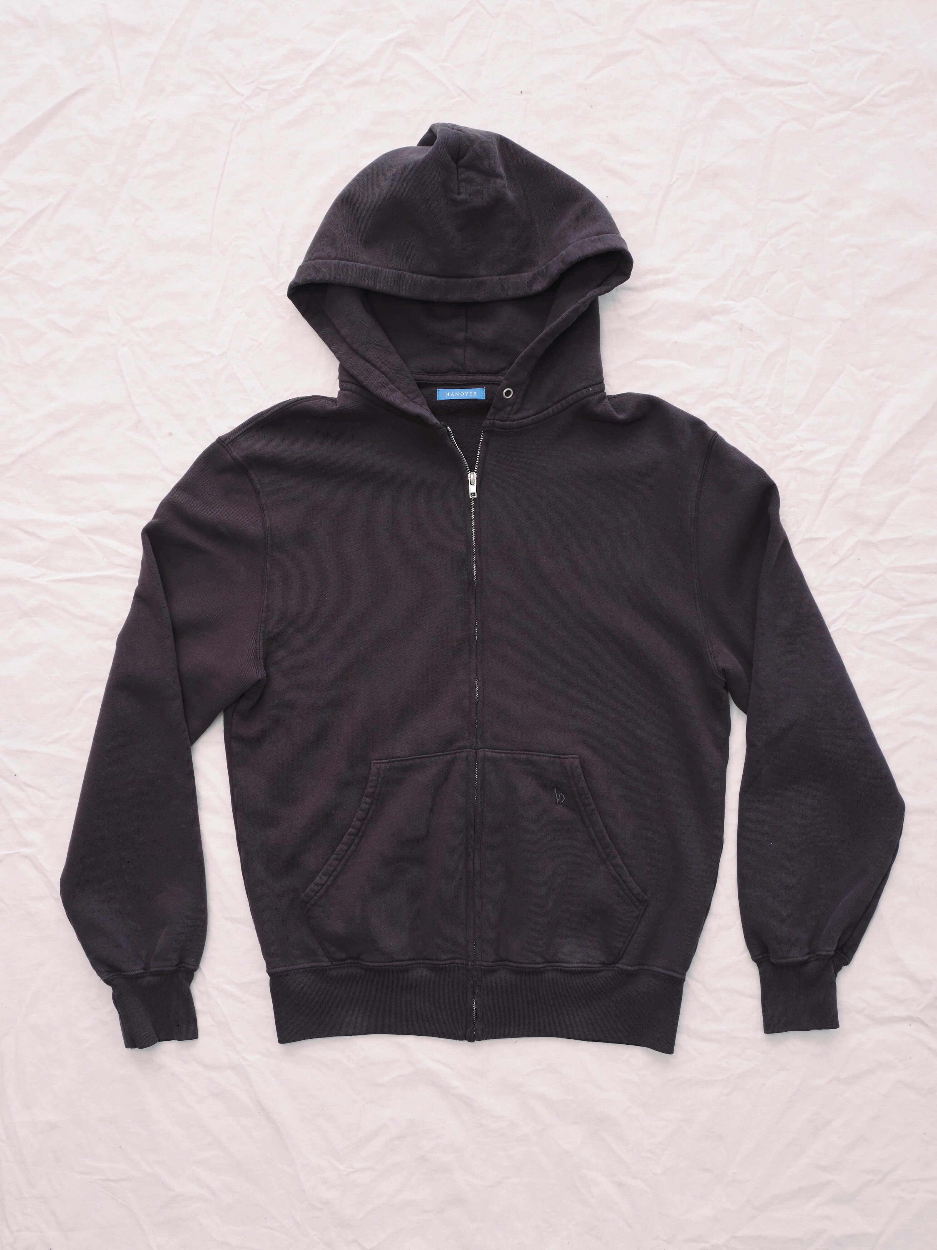 Hanover brown zip hoodie on a white quilted surface