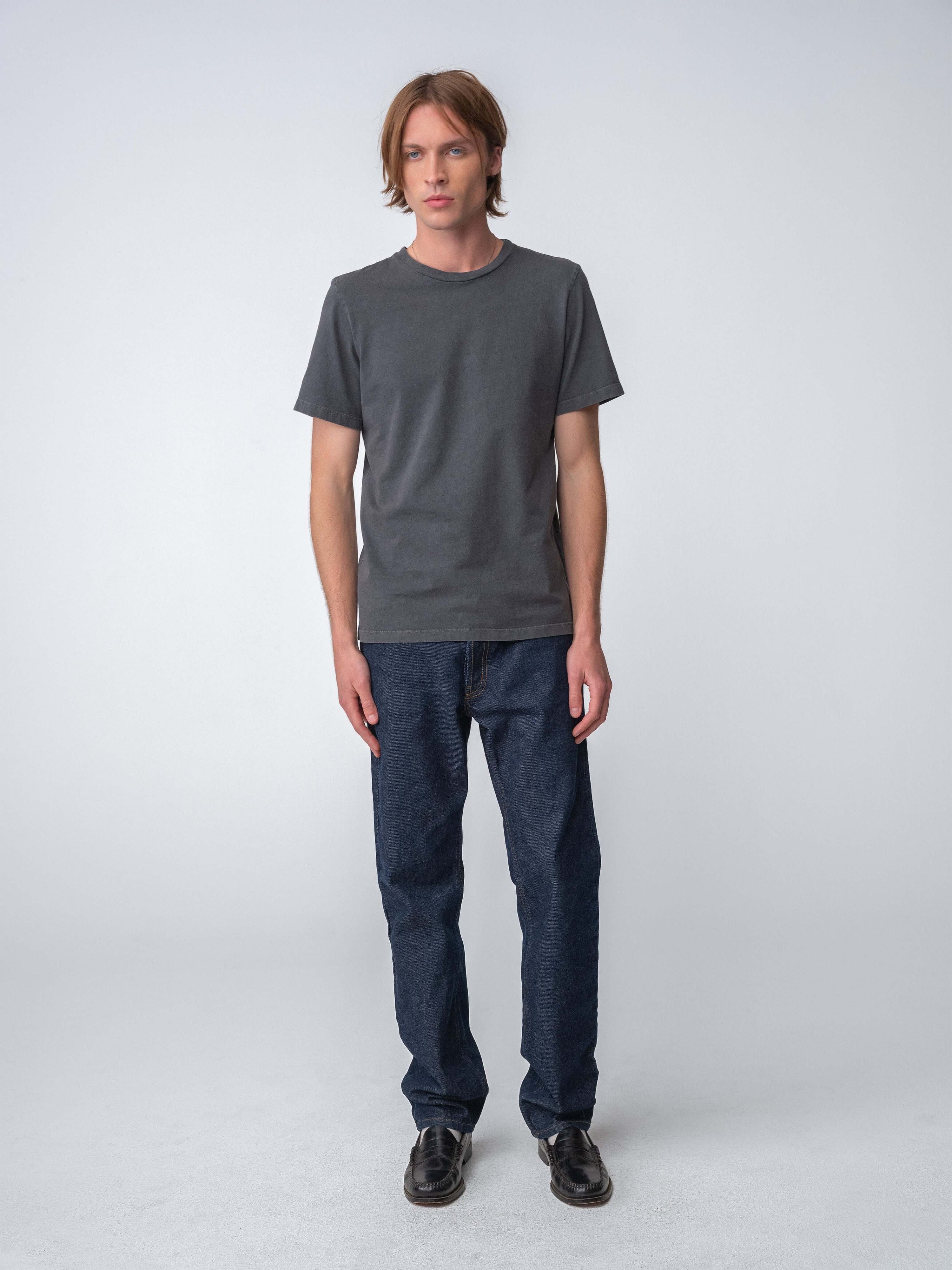 Man wearing Drift Jeans in Washed Black and a gray t-shirt against a neutral background.
