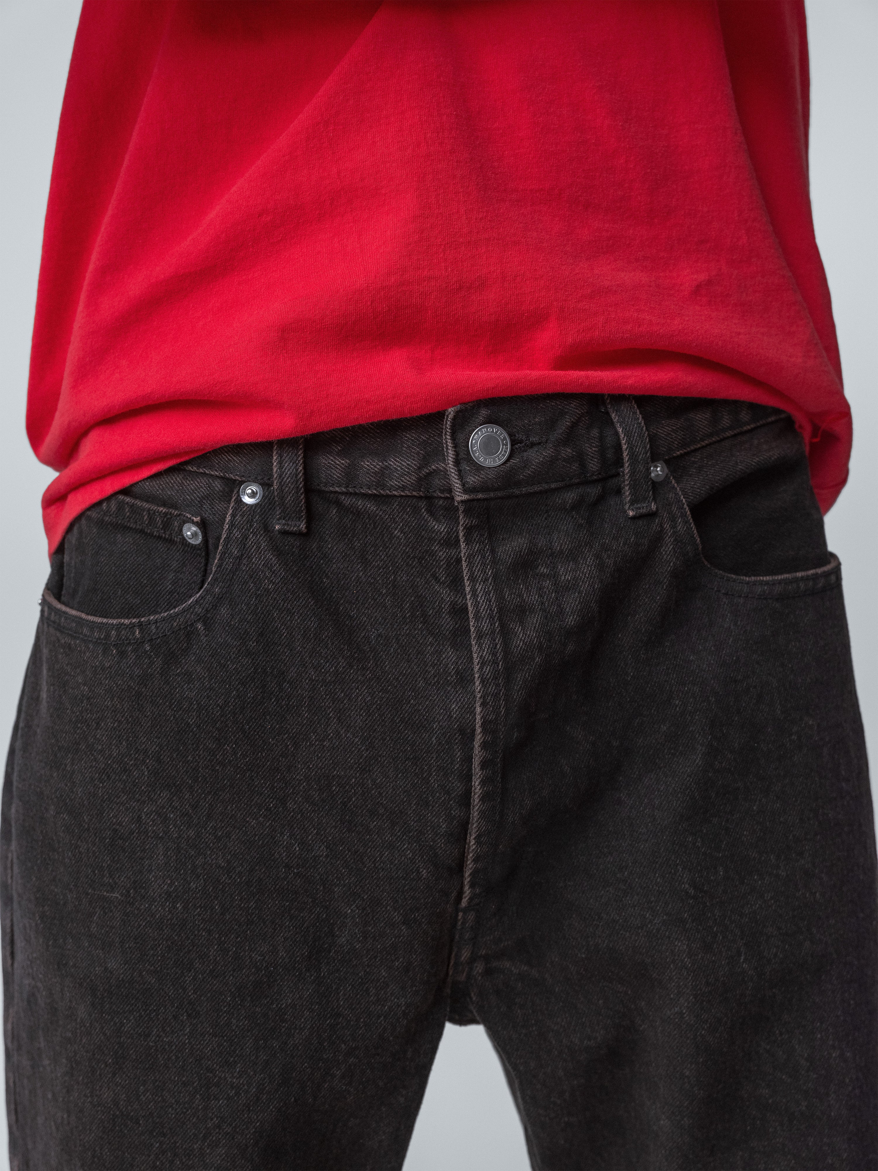 Drift Jeans in washed black denim, showcasing classic straight-fit cut, paired with a red shirt.