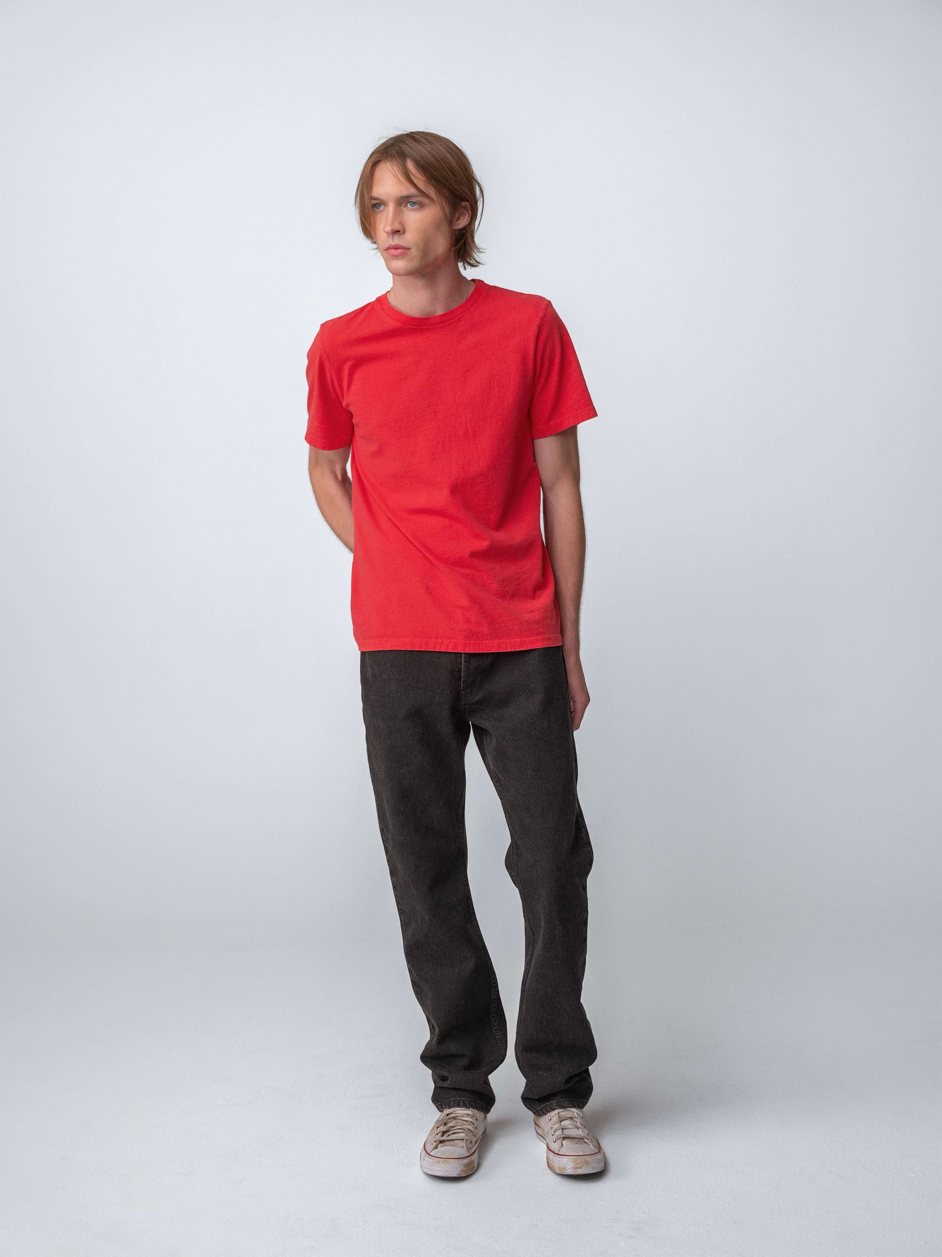 Model wearing Drift Jeans in Washed Black, paired with a red t-shirt, showcasing stylish casual wear.