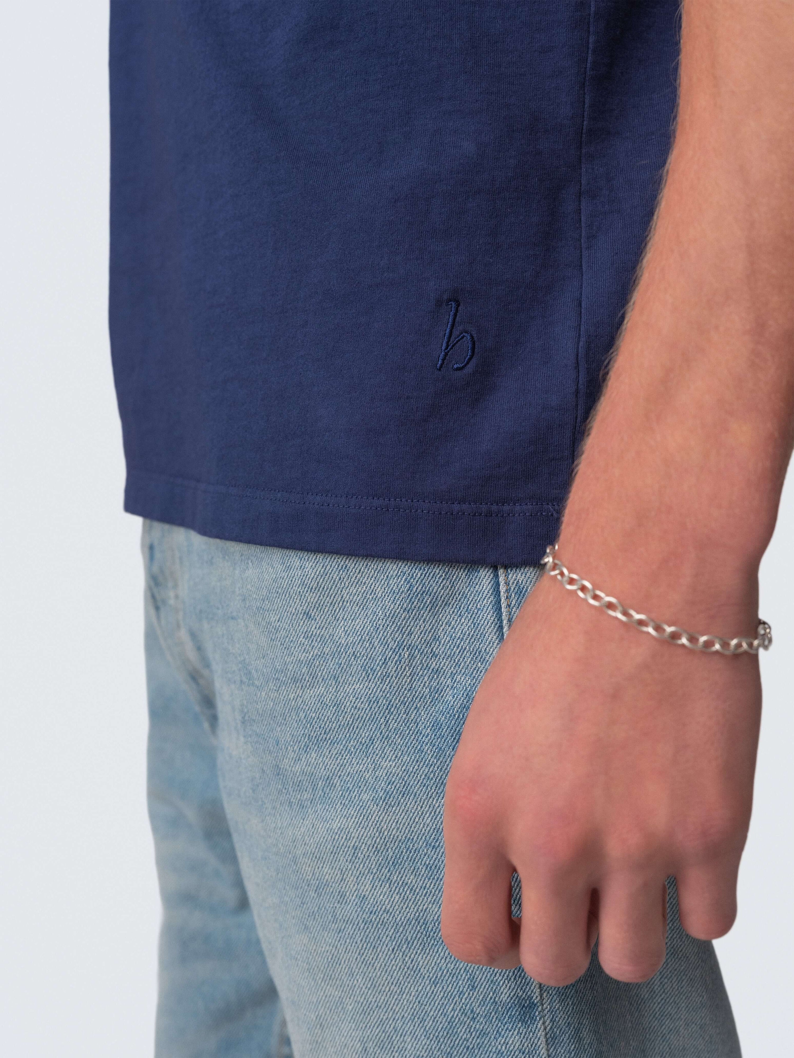 Drift Jeans worn with a navy blue shirt and showcasing a stylish bracelet for a casual look.
